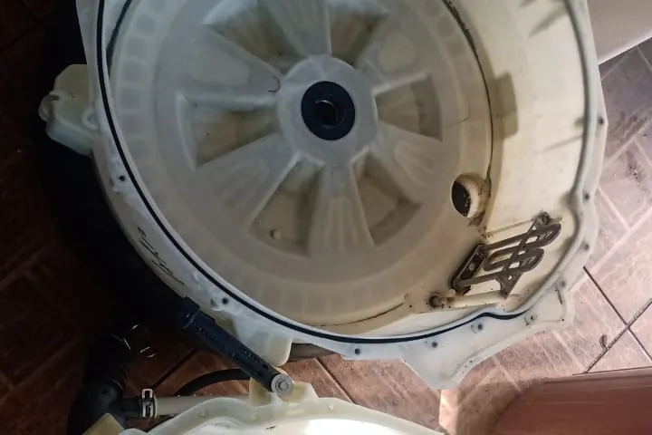 Tanque e cesto de lavadora desmontados para conserto