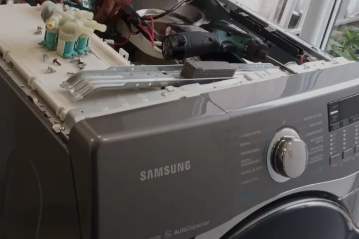 Técnico da MMAC Tec abrindo uma lava e seca Samsung para conserto
